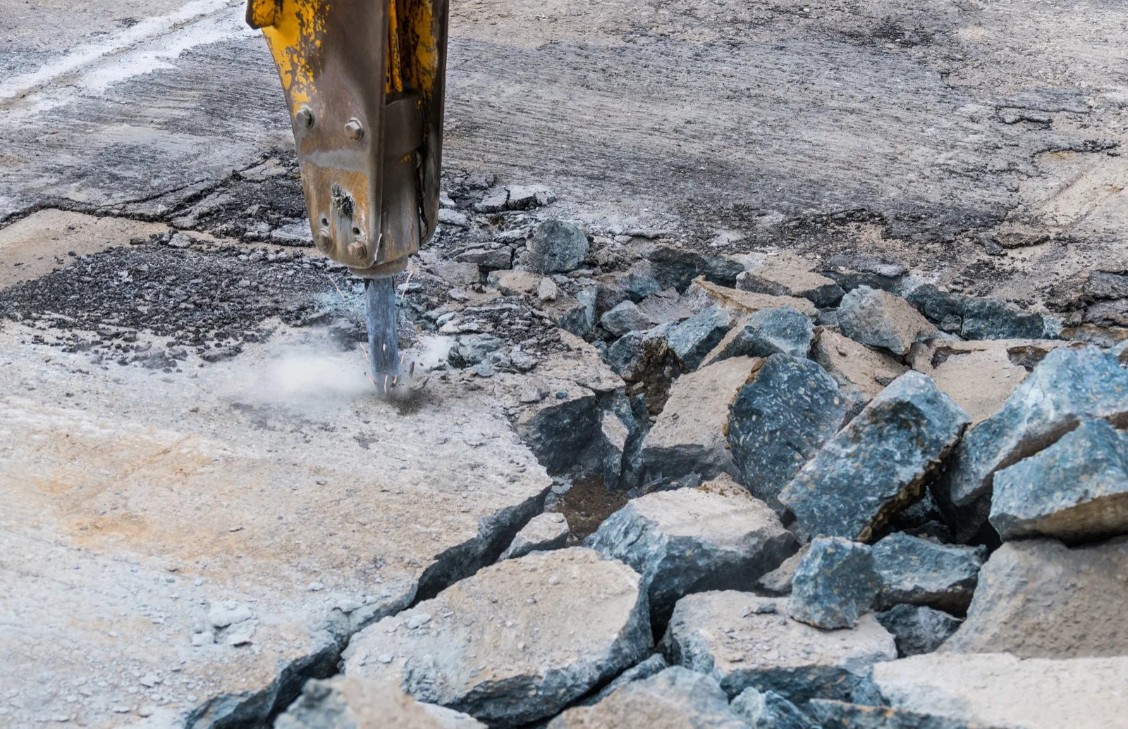 Hydraulic breaker splitting a concrete slab into pieces