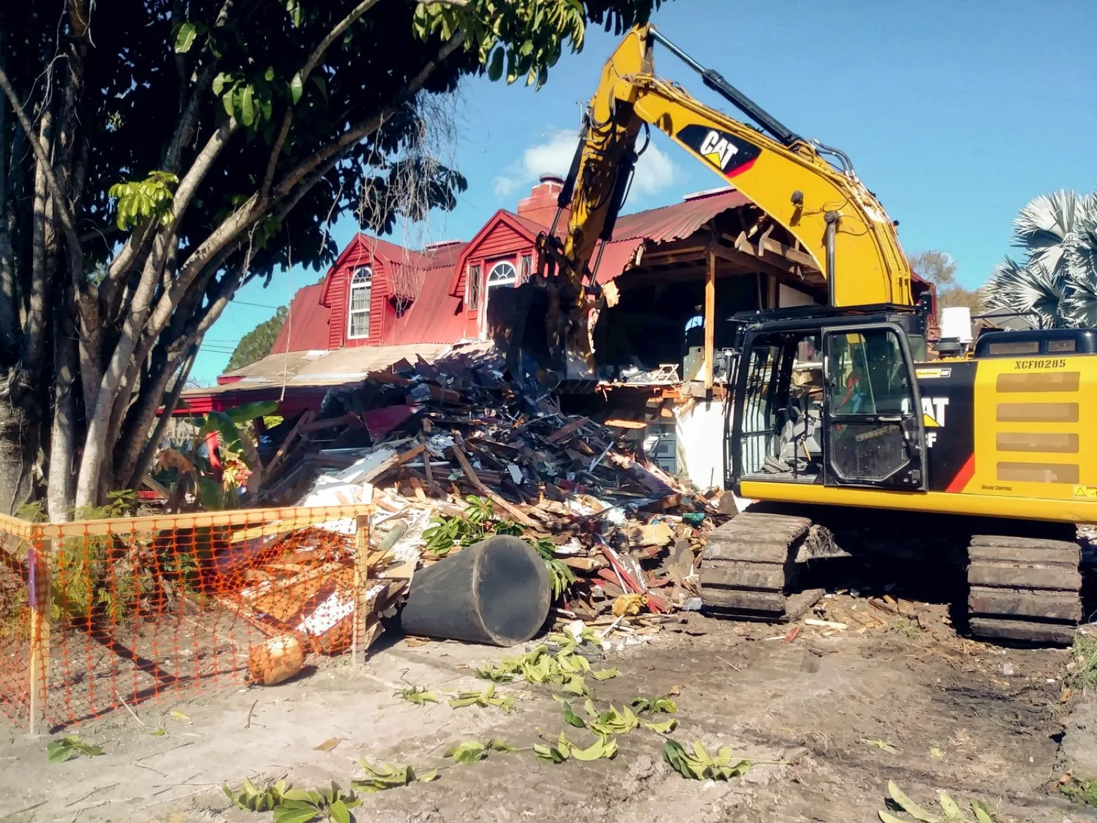 Excavator tearing down a house during demolition