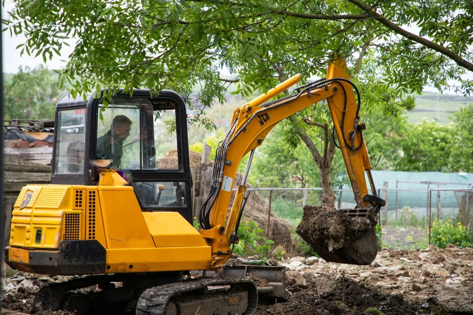 Compact excavator digging on a residential property